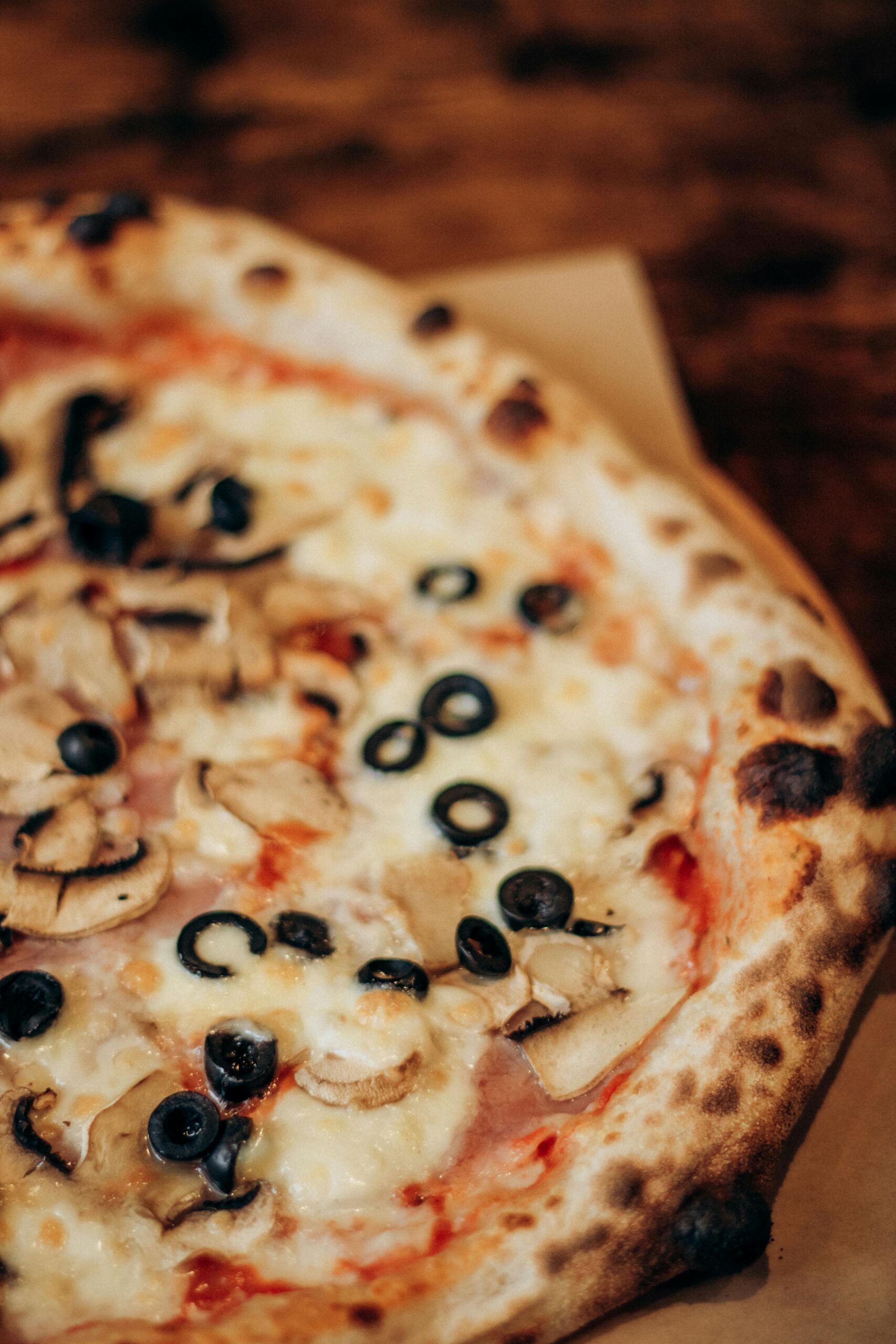 Tasty pizza topped with mushrooms, olives, and cheese. Ideal for food blogs and culinary websites.